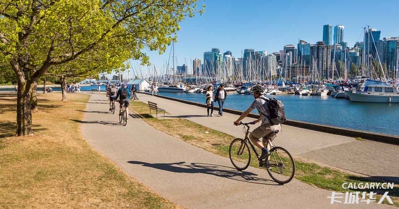 Bikers riding along the Vancouver Sea Wall.